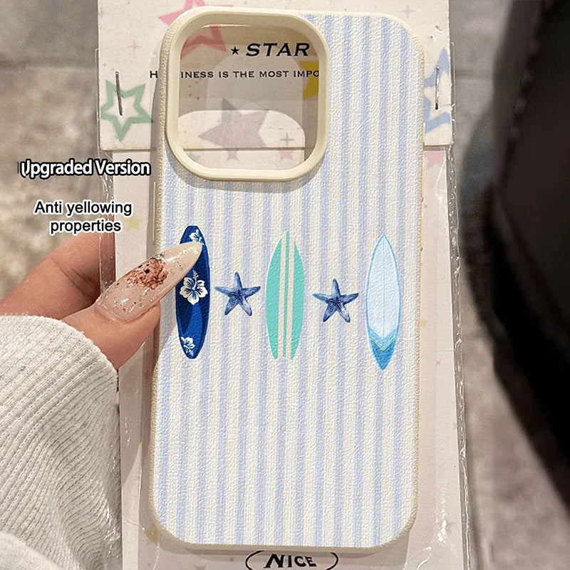 A phone case with a light blue and white vertical stripe pattern, decorated with blue and green surfboards and blue starfish motifs. The case is held by a hand with long glittery nails, and the product is still in its retail packaging with text overlays.