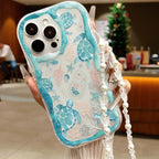 Phone case with turtle design held by a hand, blurred indoor background