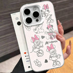 A hand holds a clear phone case featuring black-and-white line art illustrations of Minnie Mouse and hearts, with a white phone partially visible behind it. The background shows a blurred indoor setting with dark wood paneling and a wooden surface.