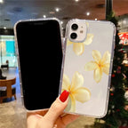 Phone case with yellow flower design held by a hand in a mall setting