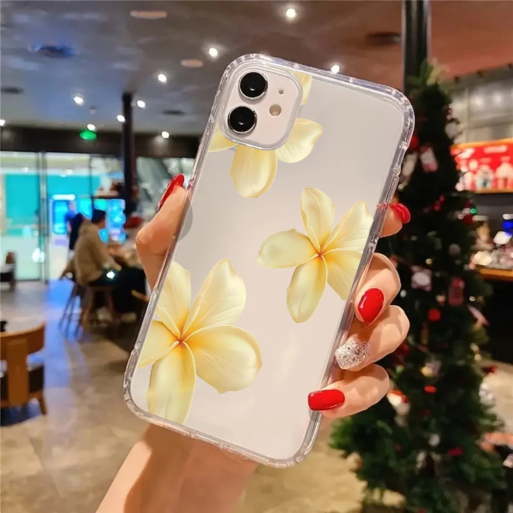 Hand holding a phone case with yellow floral design in a blurred indoor setting