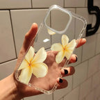 Clear phone case with yellow flowers held by a hand against a tiled wall.