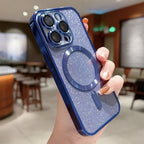 Hand holding a blue glittery phone case with a metallic ring holder in an indoor setting.