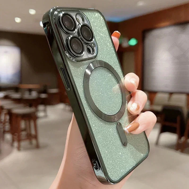 Hand holding a green glittery phone case with a metallic ring holder in an indoor setting.