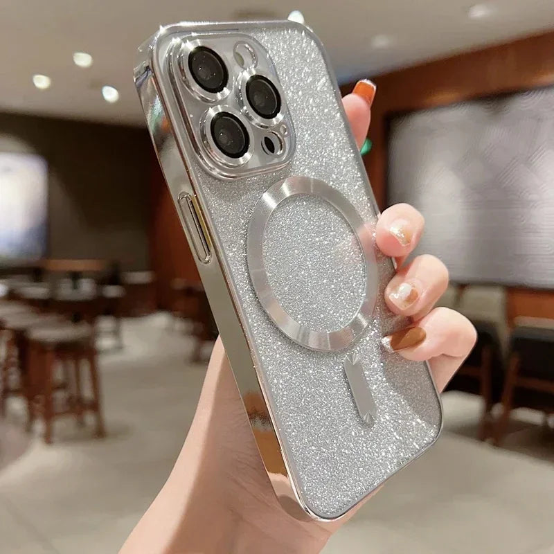Silver glittery phone case with a ring holder held by a hand in an indoor setting.
