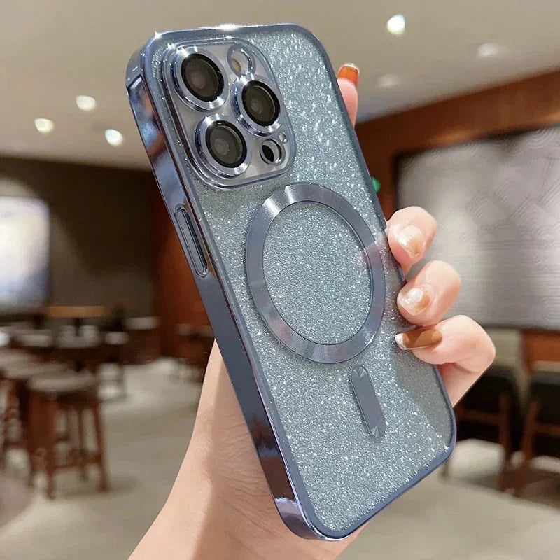 Hand holding a phone case with a glittery finish and metal ring holder in an indoor setting.