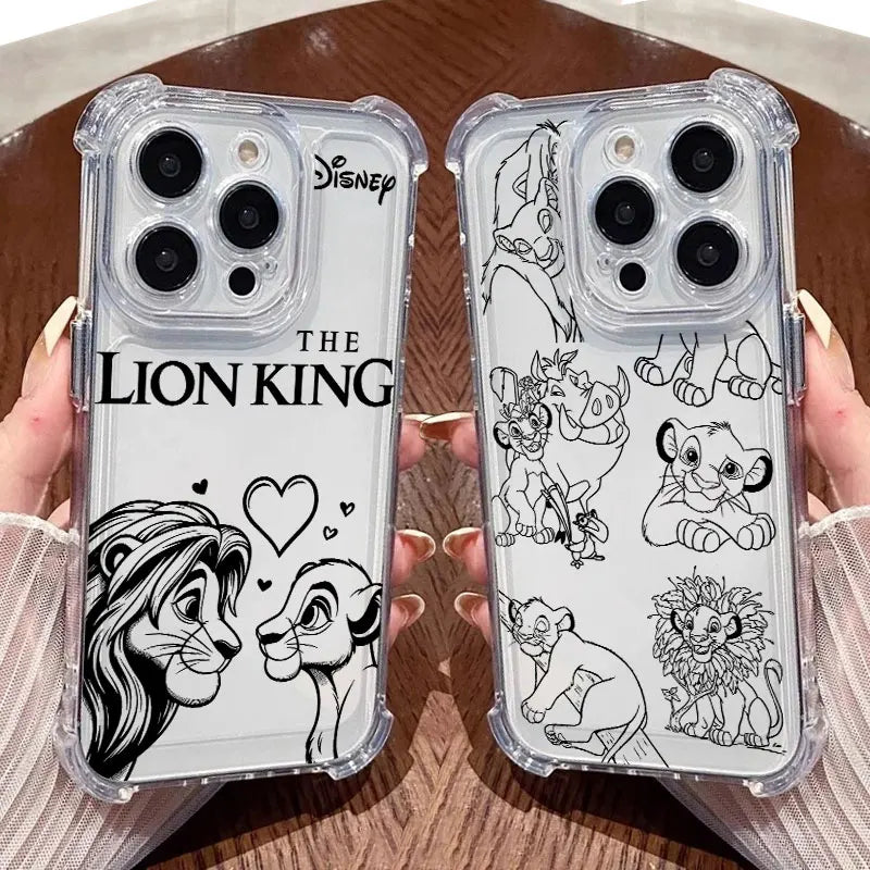 Two clear phone cases with black printed Disney The Lion King artwork are held by hands over a brown wooden surface. One case shows a large lion face and the title 'THE LION KING,' and the other shows multiple lion characters in line art.