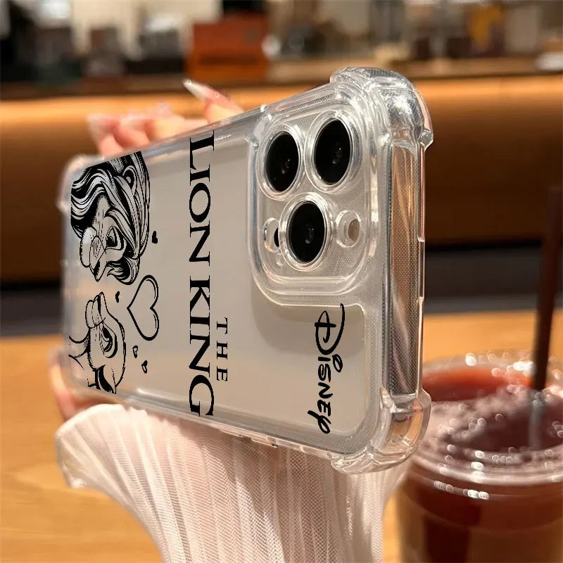 A clear protective phone case with black printed graphics of Tiana and 'THE LION KING' text, held by a hand in a cafe setting with a drink in the background.