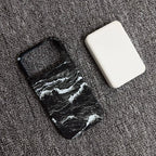Phone case with wave design and white square object on gray surface