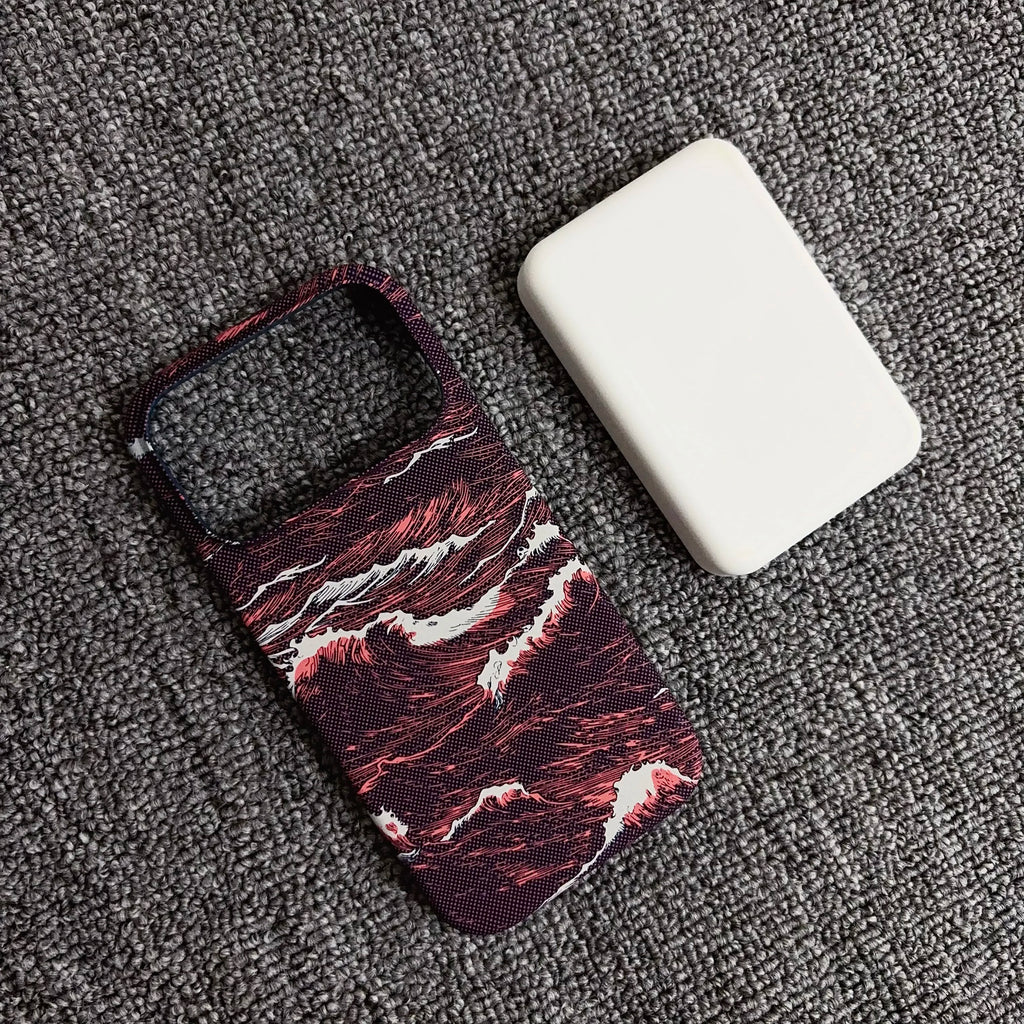A phone case with a dark red and black marble wave pattern, shown next to a white rectangular protective cover on a textured gray carpet.