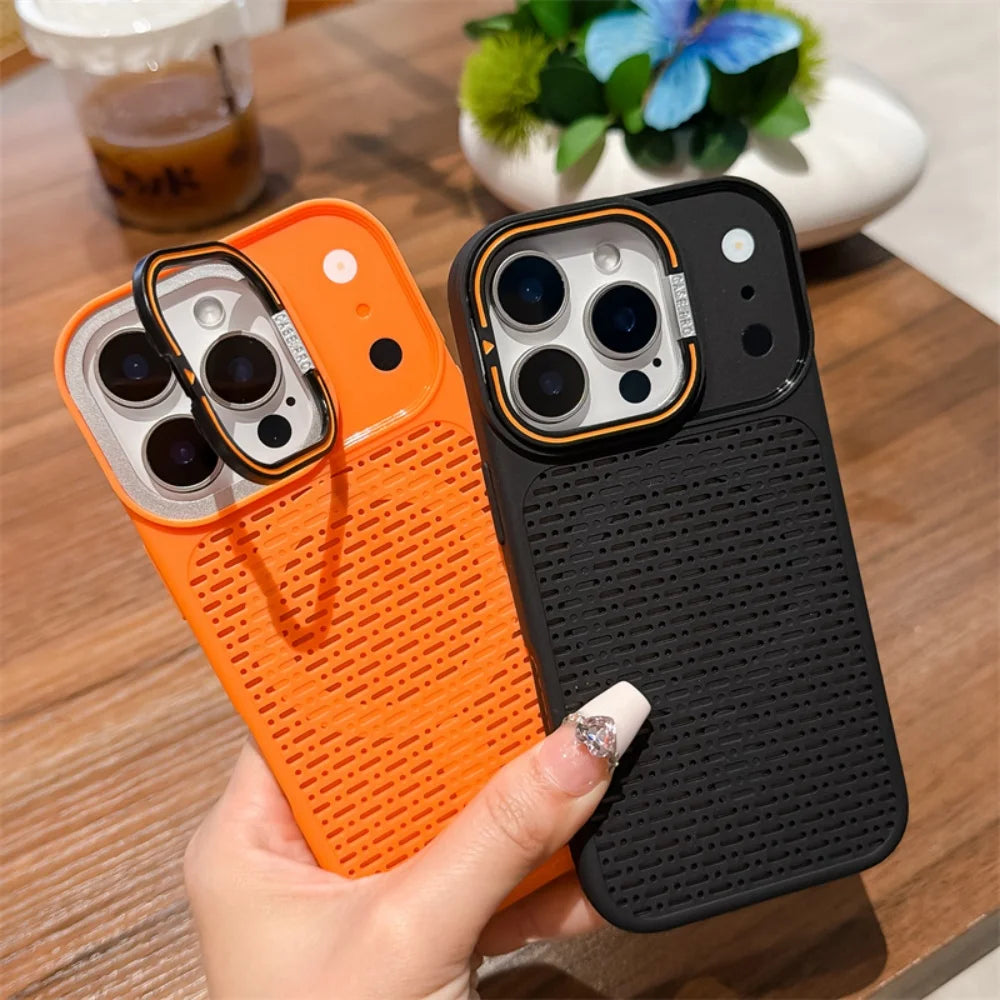 Two textured phone cases, one bright orange and one black with a gold accent ring, held in a hand over a wooden table background.