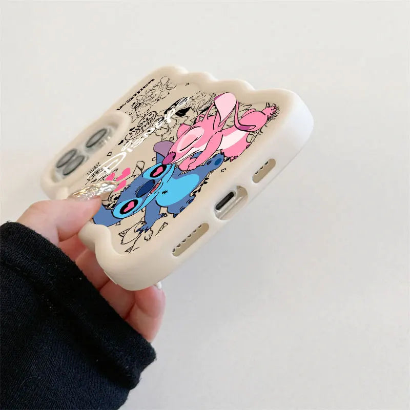 A hand holding a cream-colored phone case featuring a cartoon character print in pink and blue, with black doodle-style text and line art, against a plain light background.