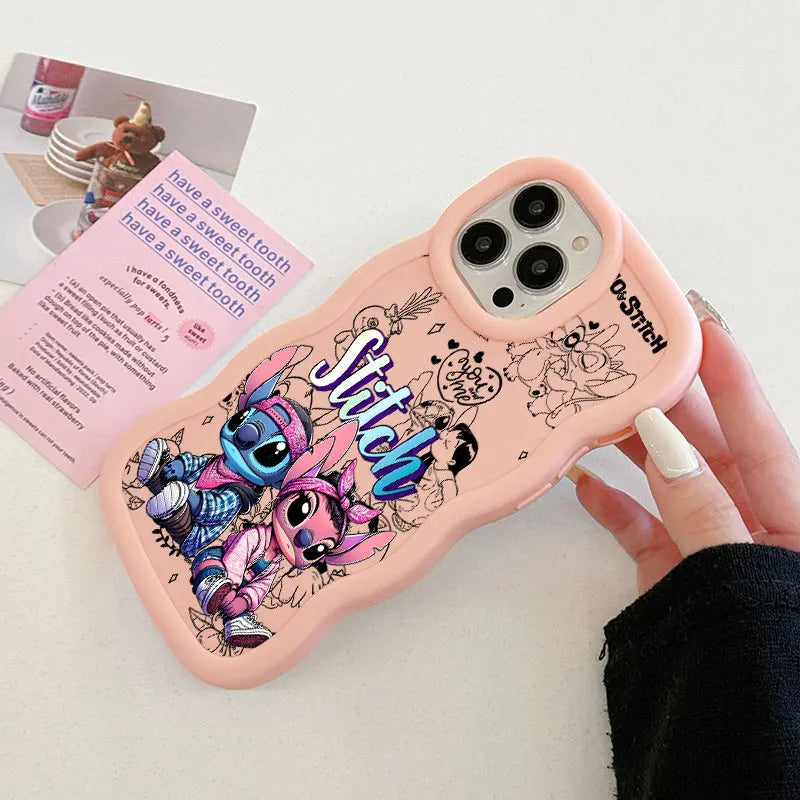 A pink phone case featuring Stitch and Angel illustrations, held by a hand. The case has a wavy border, a camera cutout, and a Disney logo printed on the side.