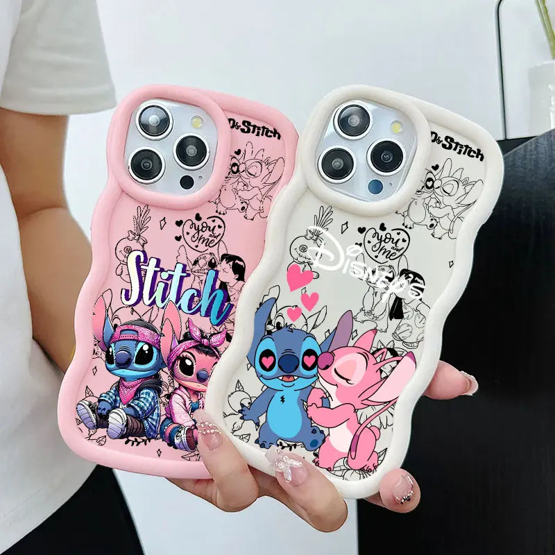 Two cartoon phone cases held in a person's hands. One case is pink with Stitch and Angel illustrations, and the other is white with black line art of Stitch and Angel with pink hearts.