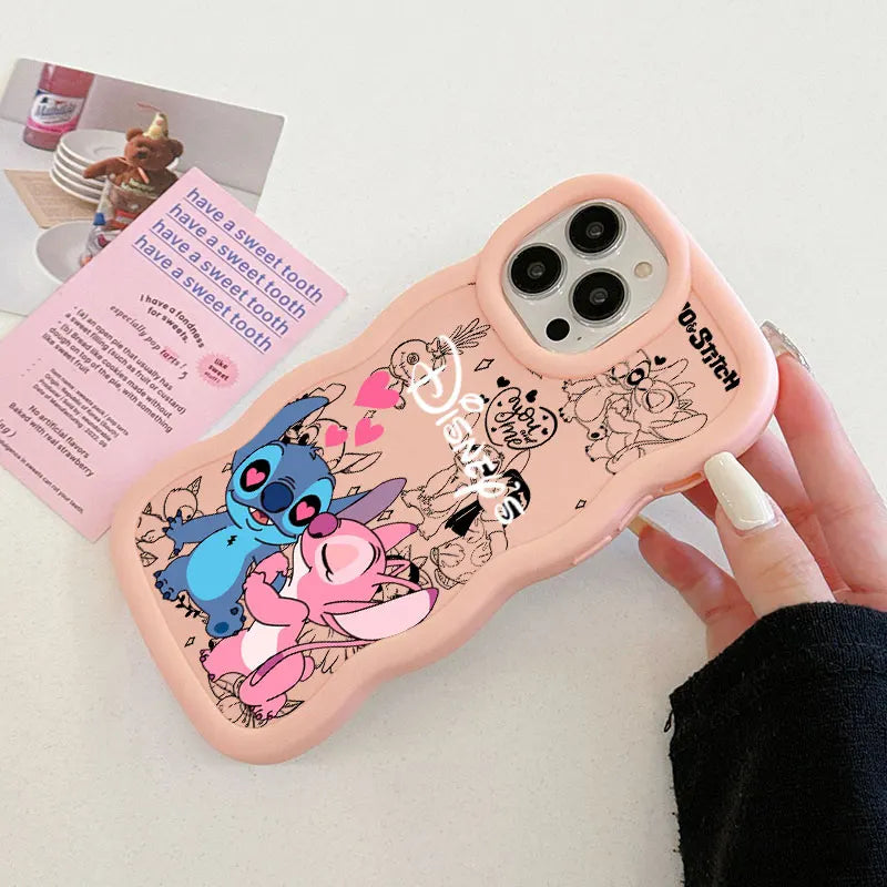 A pink phone case with cartoon character prints, held by a hand. The case features Stitch, Angel, and Disney-themed doodles.